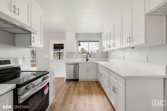 kitchen with light wood-style flooring, under cabinet range hood, stainless steel appliances, white cabinets, and light countertops