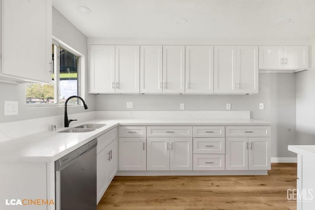 kitchen featuring dishwasher, light countertops, white cabinetry, and a sink