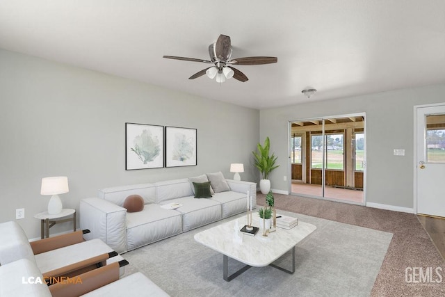 carpeted living area with baseboards and ceiling fan