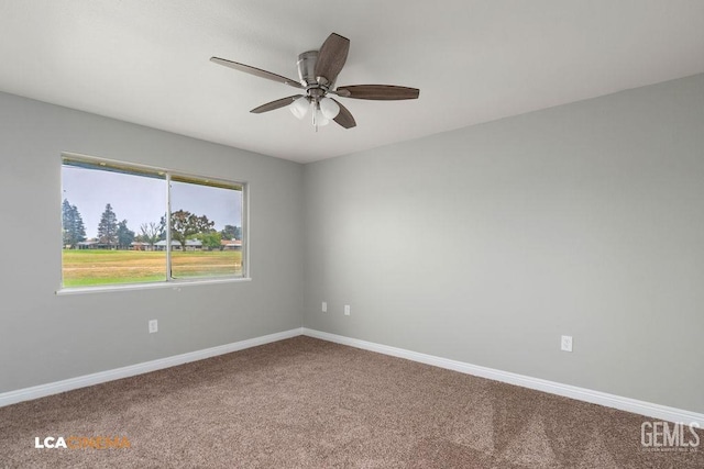 spare room with carpet flooring, baseboards, and ceiling fan