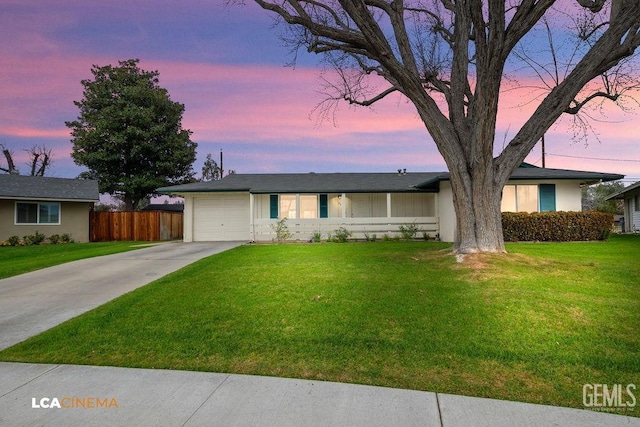 ranch-style house with concrete driveway, fence, a garage, and a front lawn