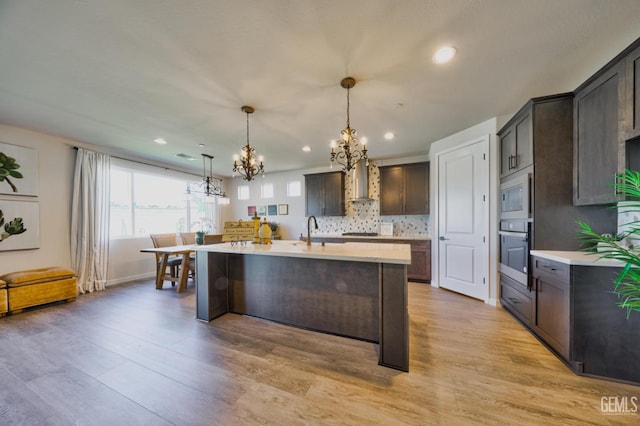 kitchen with a notable chandelier, light countertops, dark brown cabinets, and stainless steel appliances