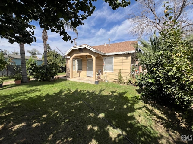 view of front of house with a porch, a front yard, and a shingled roof