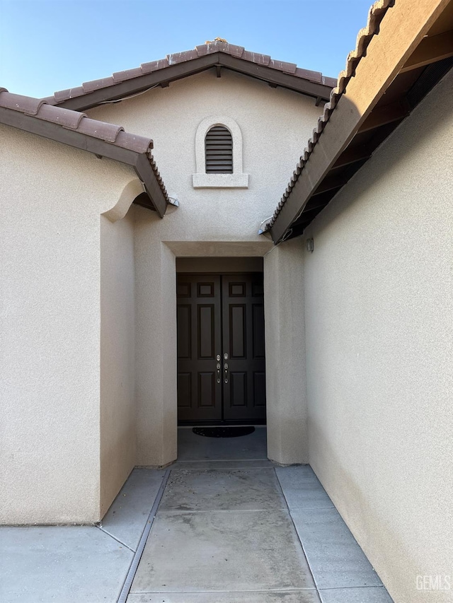 7904 Bristol Spring Ave, Bakersfield, CA 93313 - doorway to property with stucco siding and a tiled roof