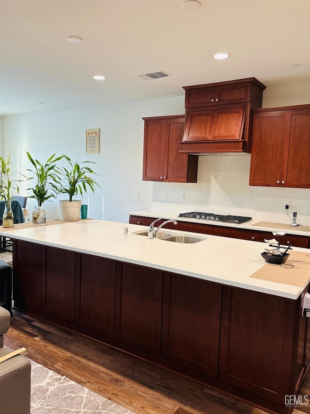 7904 Bristol Spring Ave, Bakersfield, CA 93313 - kitchen with a sink, custom exhaust hood, stainless steel gas cooktop, light countertops, and dark wood finished floors