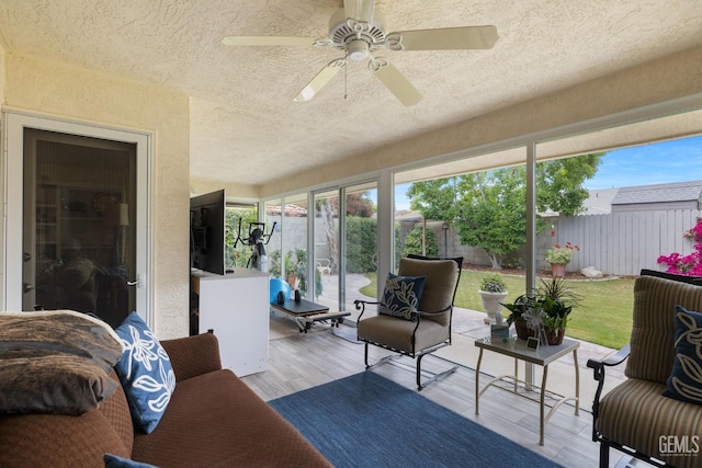 sunroom / solarium featuring a textured ceiling, ceiling fan, and wood finished floors