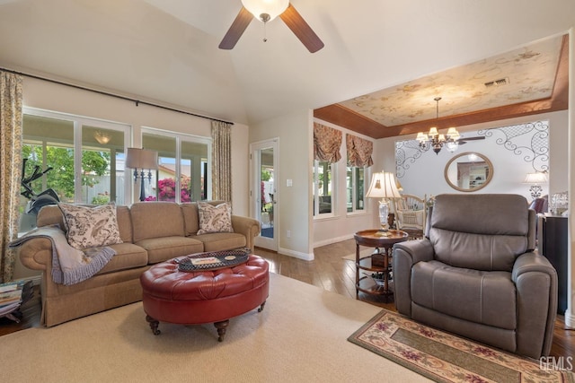 living area featuring ceiling fan with notable chandelier, baseboards, wood finished floors, vaulted ceiling, and visible vents