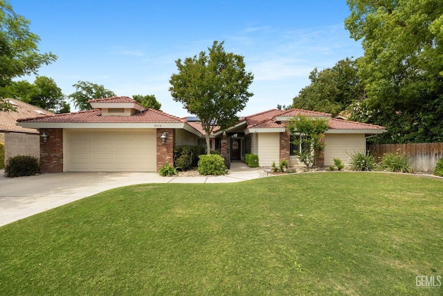 view of front facade with a tiled roof, fence, concrete driveway, and a garage