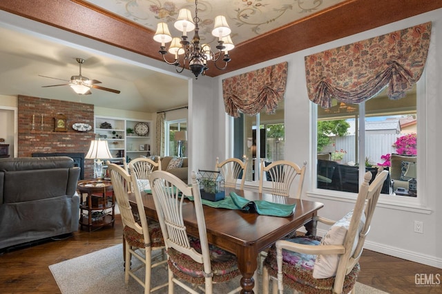 dining space with baseboards, ceiling fan with notable chandelier, wood finished floors, and lofted ceiling