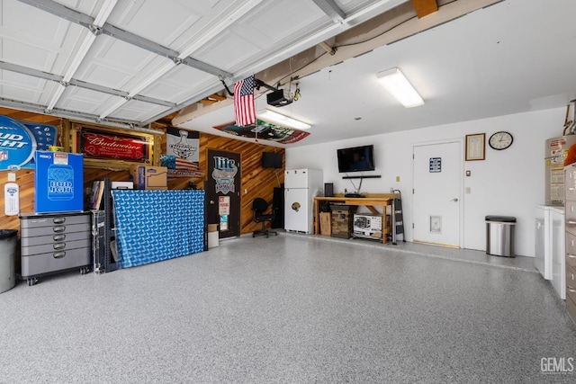 garage with freestanding refrigerator and a garage door opener