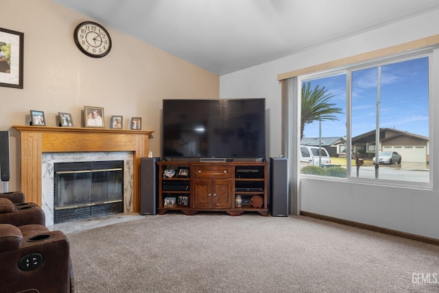 living room featuring lofted ceiling, carpet, baseboards, and a high end fireplace