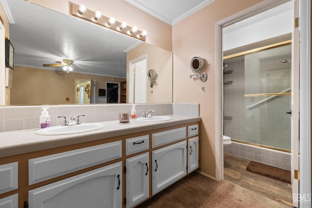 bathroom featuring ornamental molding, a stall shower, a sink, and backsplash