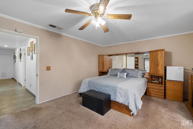 bedroom with ornamental molding, visible vents, baseboards, and a ceiling fan