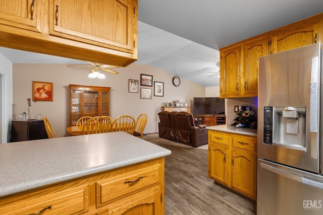 kitchen featuring lofted ceiling, ceiling fan, stainless steel refrigerator with ice dispenser, and dark wood finished floors