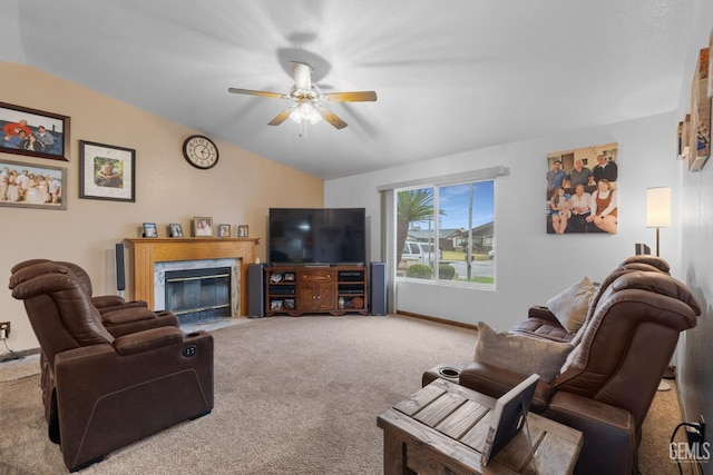 carpeted living area featuring vaulted ceiling, a premium fireplace, a ceiling fan, and baseboards