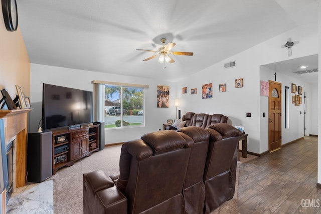 living room with visible vents, a fireplace with flush hearth, vaulted ceiling, ceiling fan, and baseboards