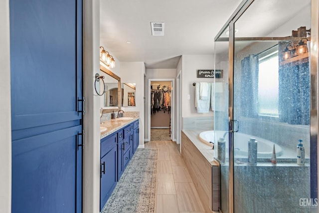 bathroom featuring tile patterned flooring, vanity, and shower with separate bathtub