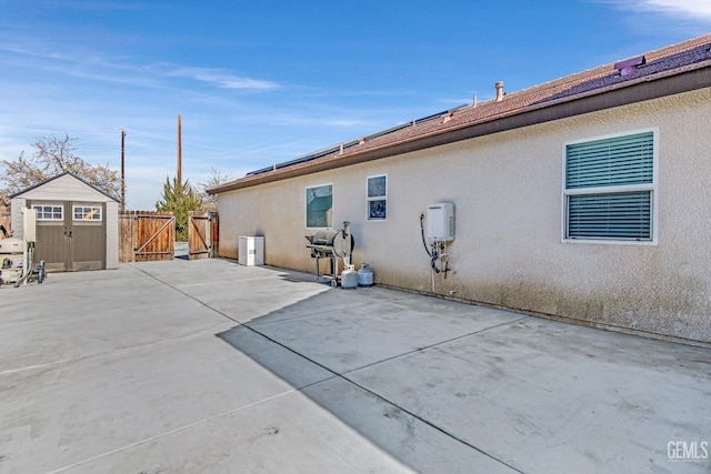 view of property exterior featuring a patio and a storage shed