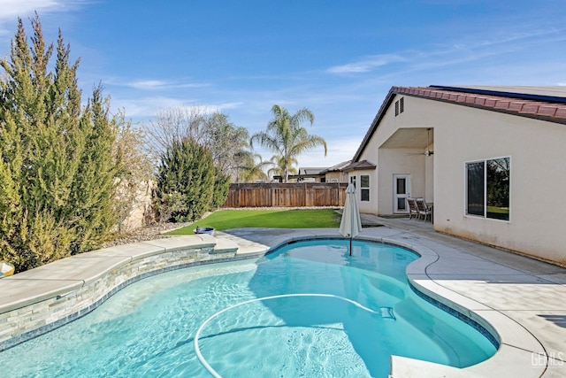 view of swimming pool featuring ceiling fan, a patio, and a lawn