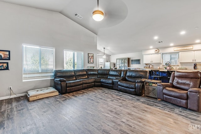 living room featuring ceiling fan, lofted ceiling, and light wood-type flooring