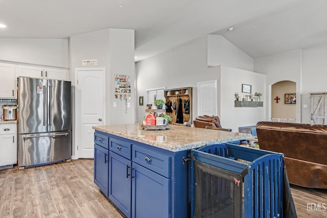 kitchen featuring blue cabinetry, high quality fridge, light wood-type flooring, and white cabinets