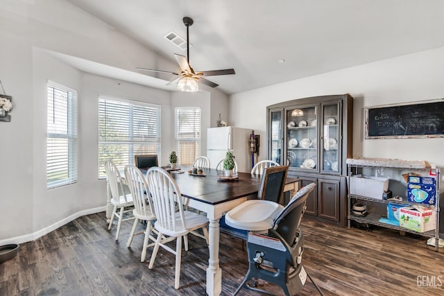 dining area with ceiling fan, dark hardwood / wood-style flooring, and vaulted ceiling