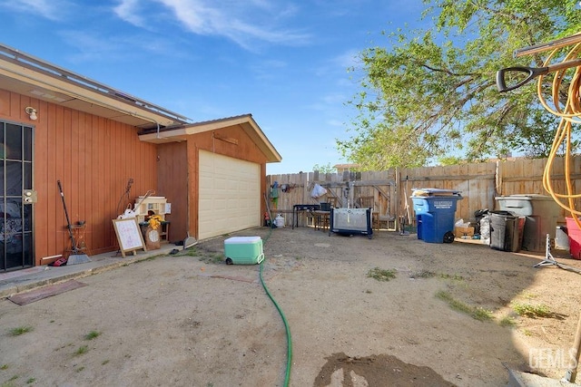 view of yard with fence and a garage