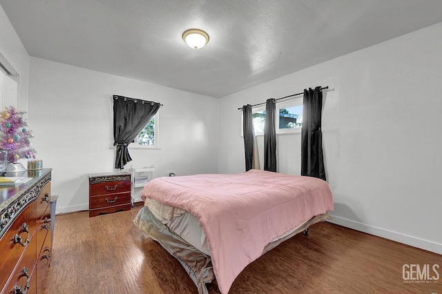 bedroom featuring wood finished floors and baseboards