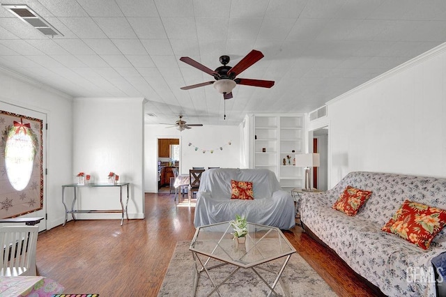 living room featuring wood finished floors, visible vents, built in shelves, and ceiling fan