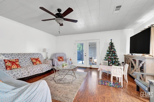 living area featuring french doors, visible vents, a ceiling fan, wood finished floors, and crown molding