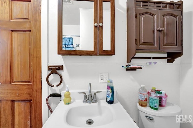 bathroom with visible vents, toilet, and a sink