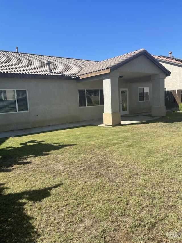 10931 Vista Del Valle Dr, Bakersfield, CA 93311 - back of house featuring a tiled roof, stucco siding, a patio area, and a lawn