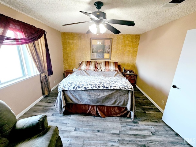 bedroom with dark wood-type flooring, a textured ceiling, and ceiling fan