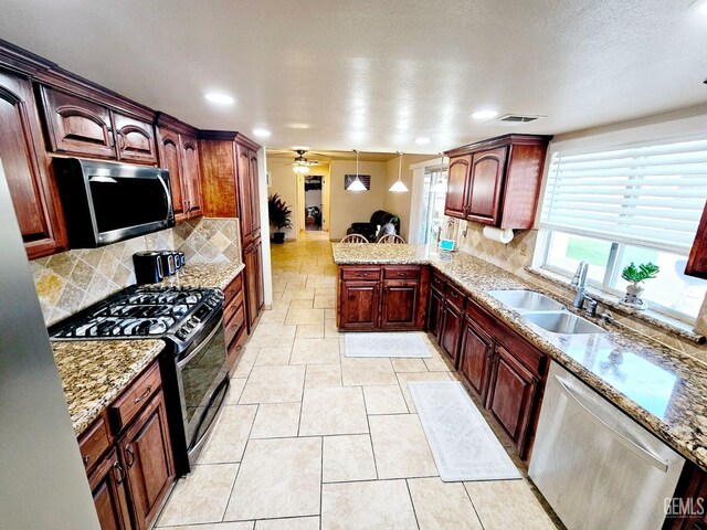 kitchen with sink, gas range, decorative light fixtures, dishwasher, and decorative backsplash