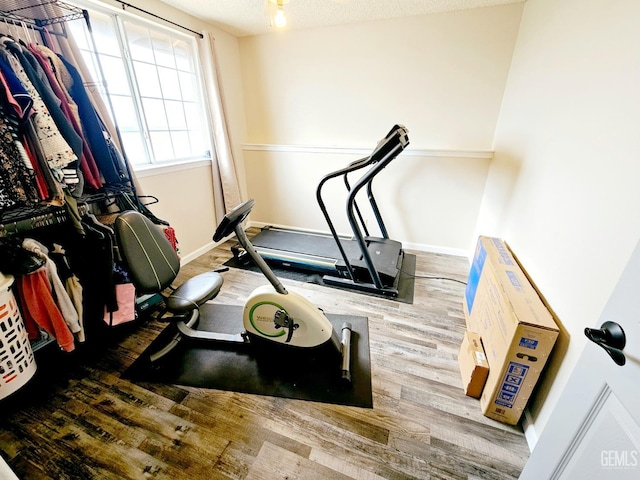 workout area with wood-type flooring and a textured ceiling