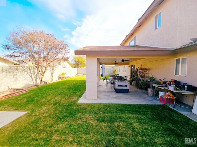 view of yard featuring ceiling fan and a patio