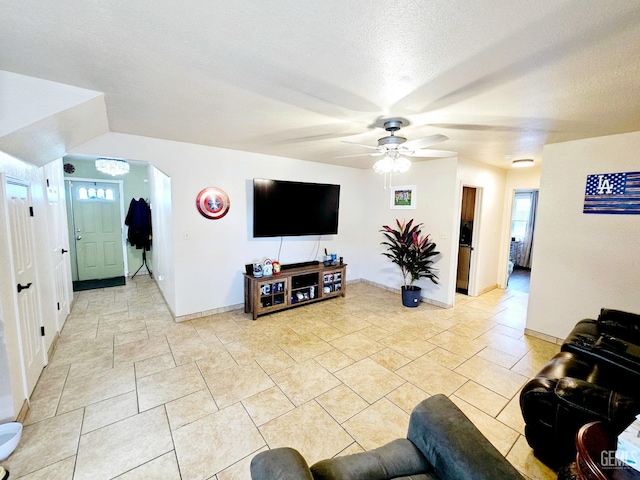 living room with a textured ceiling and ceiling fan