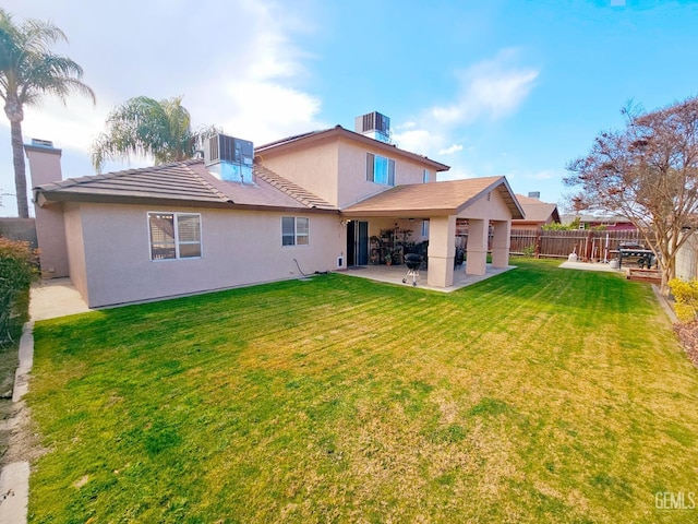 rear view of property with central air condition unit, a patio area, and a lawn