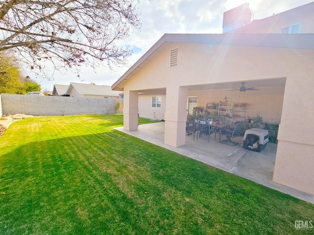 view of yard with ceiling fan and a patio