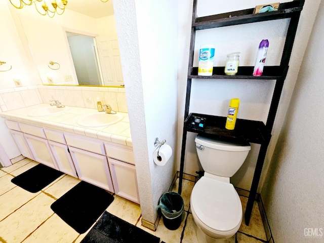 bathroom featuring decorative backsplash, vanity, tile patterned floors, and toilet