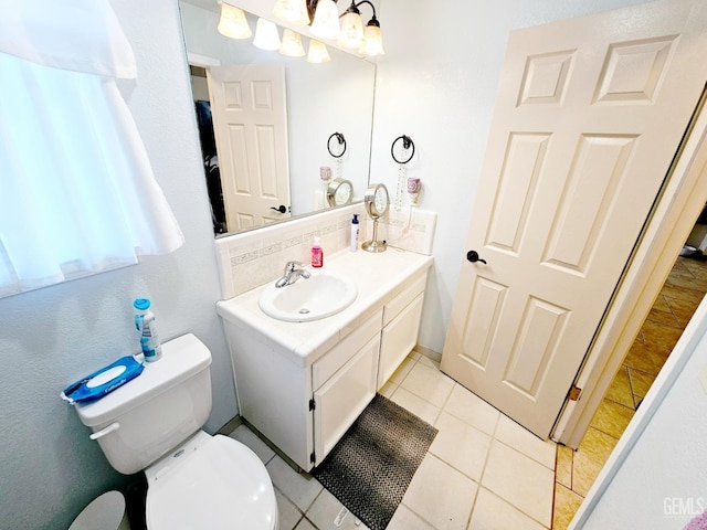 bathroom featuring decorative backsplash, tile patterned floors, toilet, and vanity