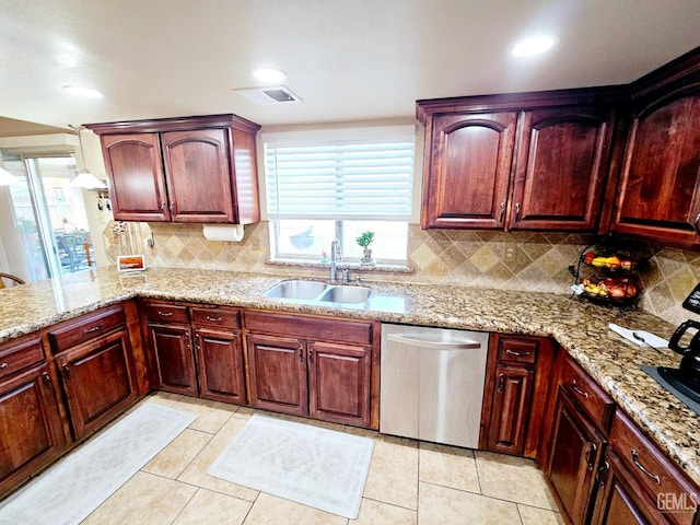 kitchen with sink, backsplash, stainless steel dishwasher, light tile patterned floors, and light stone countertops