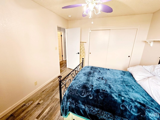 bedroom with hardwood / wood-style flooring, ceiling fan, a closet, and a textured ceiling