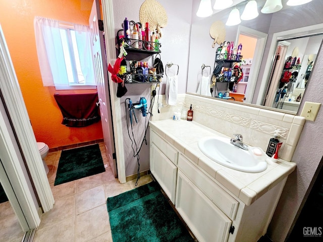 bathroom with vanity, decorative backsplash, tile patterned floors, and toilet