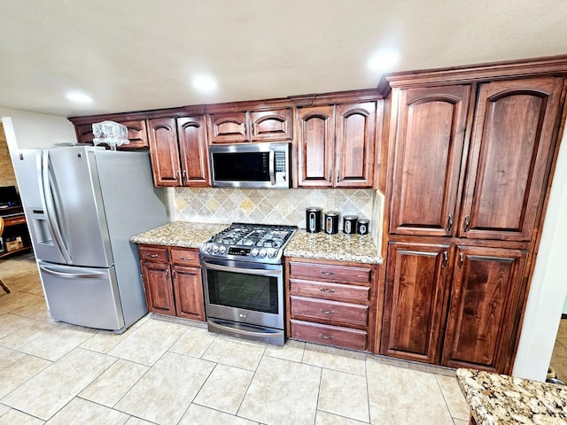 kitchen featuring light stone counters, appliances with stainless steel finishes, decorative backsplash, and light tile patterned floors