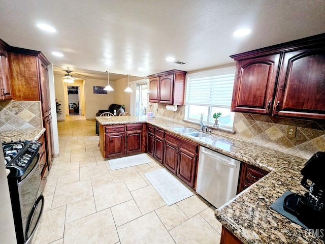 kitchen with sink, gas range oven, decorative light fixtures, stainless steel dishwasher, and kitchen peninsula