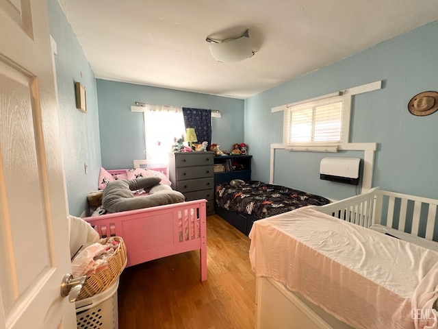 bedroom featuring multiple windows and wood finished floors