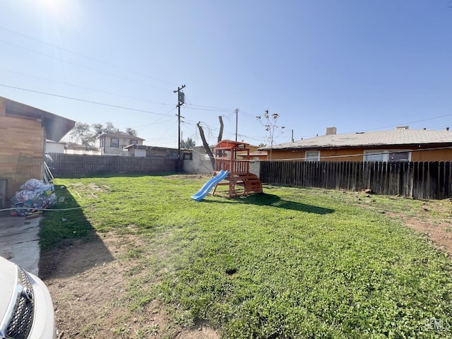 view of yard with a playground and a fenced backyard