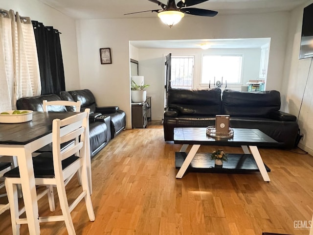 living area featuring light wood-type flooring and a ceiling fan