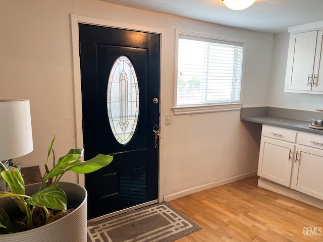 entryway featuring baseboards and light wood-style floors